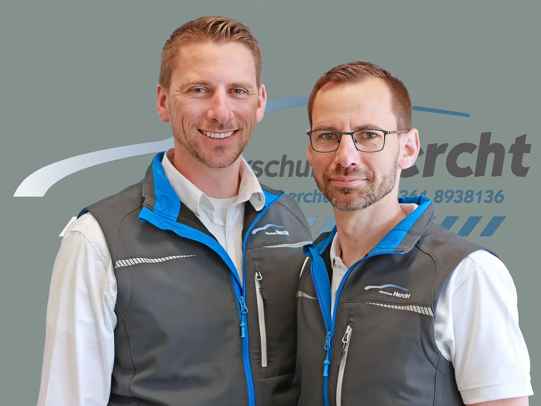 Steven und Marcus Hercht gemeinsam vor dem Fahrschullogo